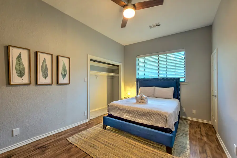 Bedroom with a blue upholstered bed, leaf prints and a closet