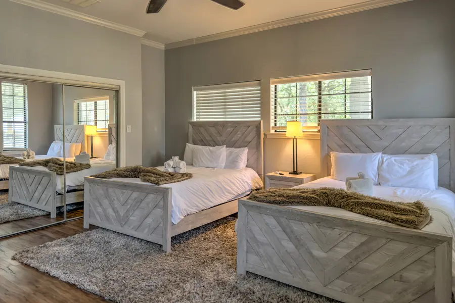 Bedroom with two beds, white bedding and a mirrored closet