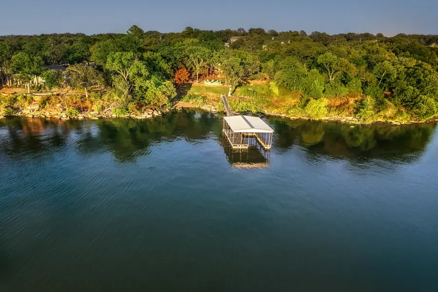 Aerial view of the covered boat dock and wooded shoreline