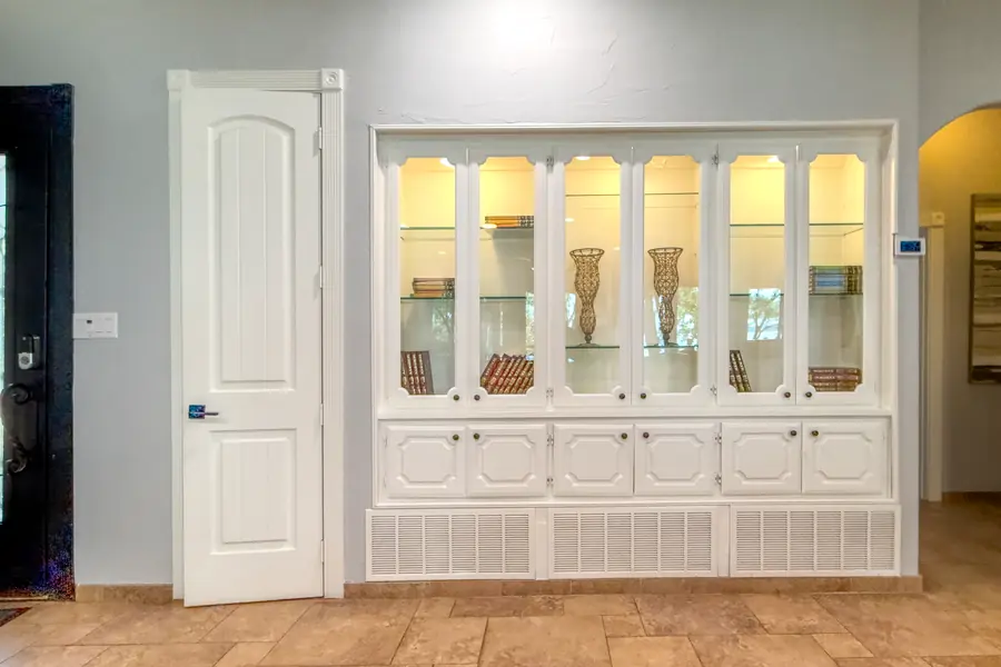 Entry hall with a lit glass-front display cabinet