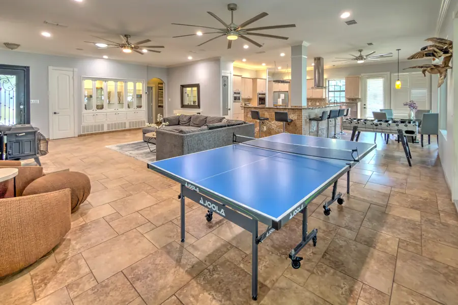 Open-plan great room with a ping-pong table, foosball table and the kitchen beyond