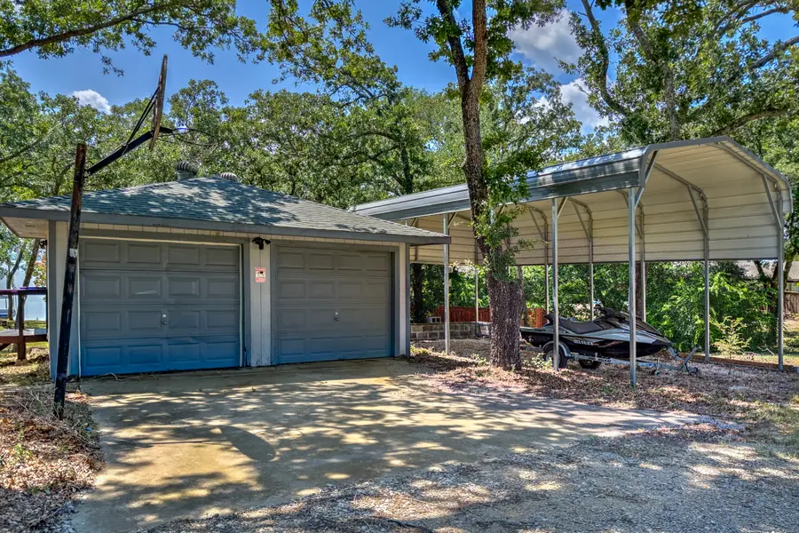 Two-car garage, carport and basketball hoop under the oaks