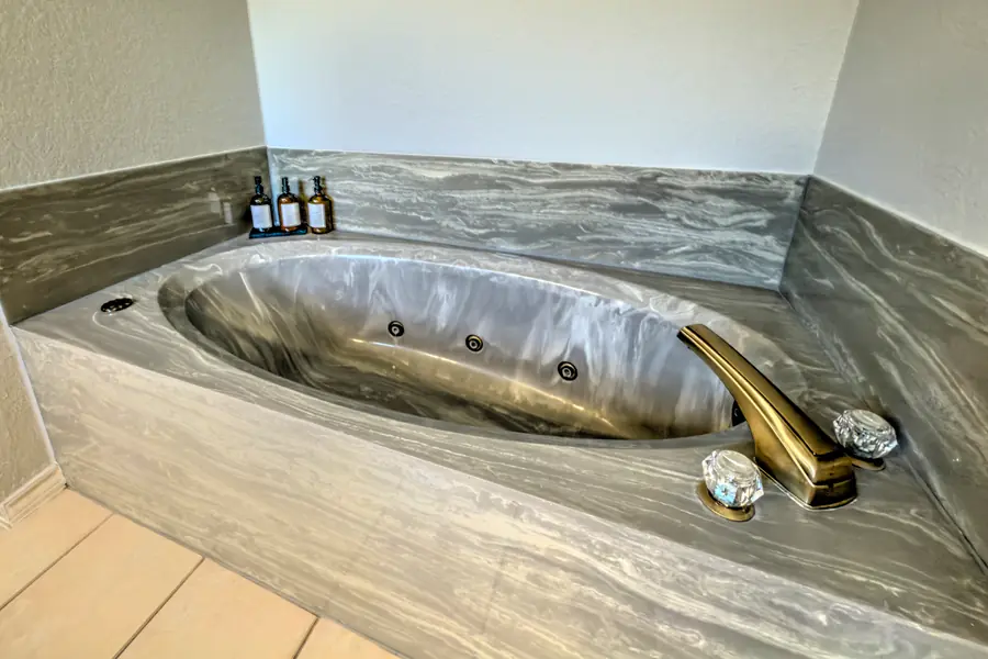 Jetted soaking tub with a marbled grey surround