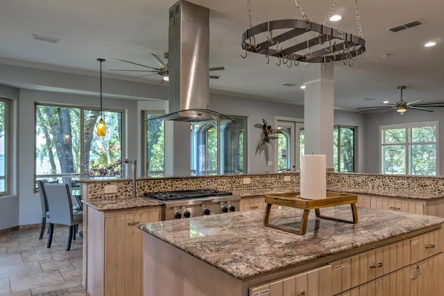 Kitchen island and gas range under a stainless hood