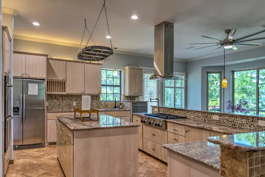 Kitchen from the refrigerator side showing the island, range and windows